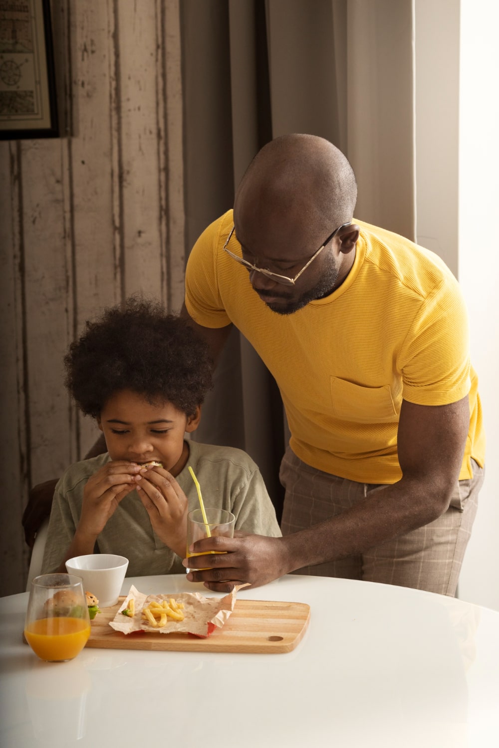 father-son-having-lunch-together-enjoying-burgers-fries-min